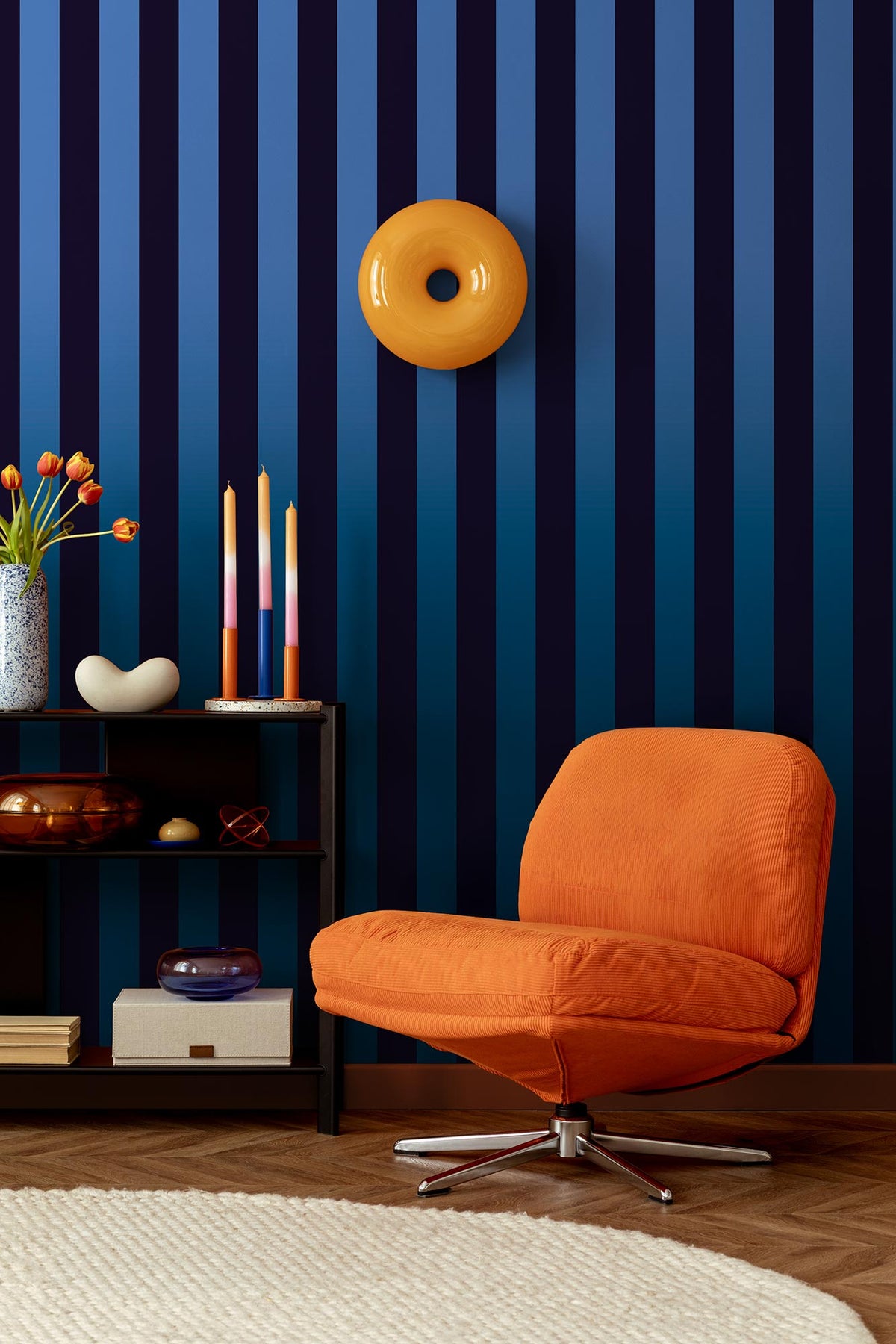 Papier peint à rayures dégradé Eliott, bleu nuit - dans un salon avec du mobilier coloré d'inspiration pop 70's
