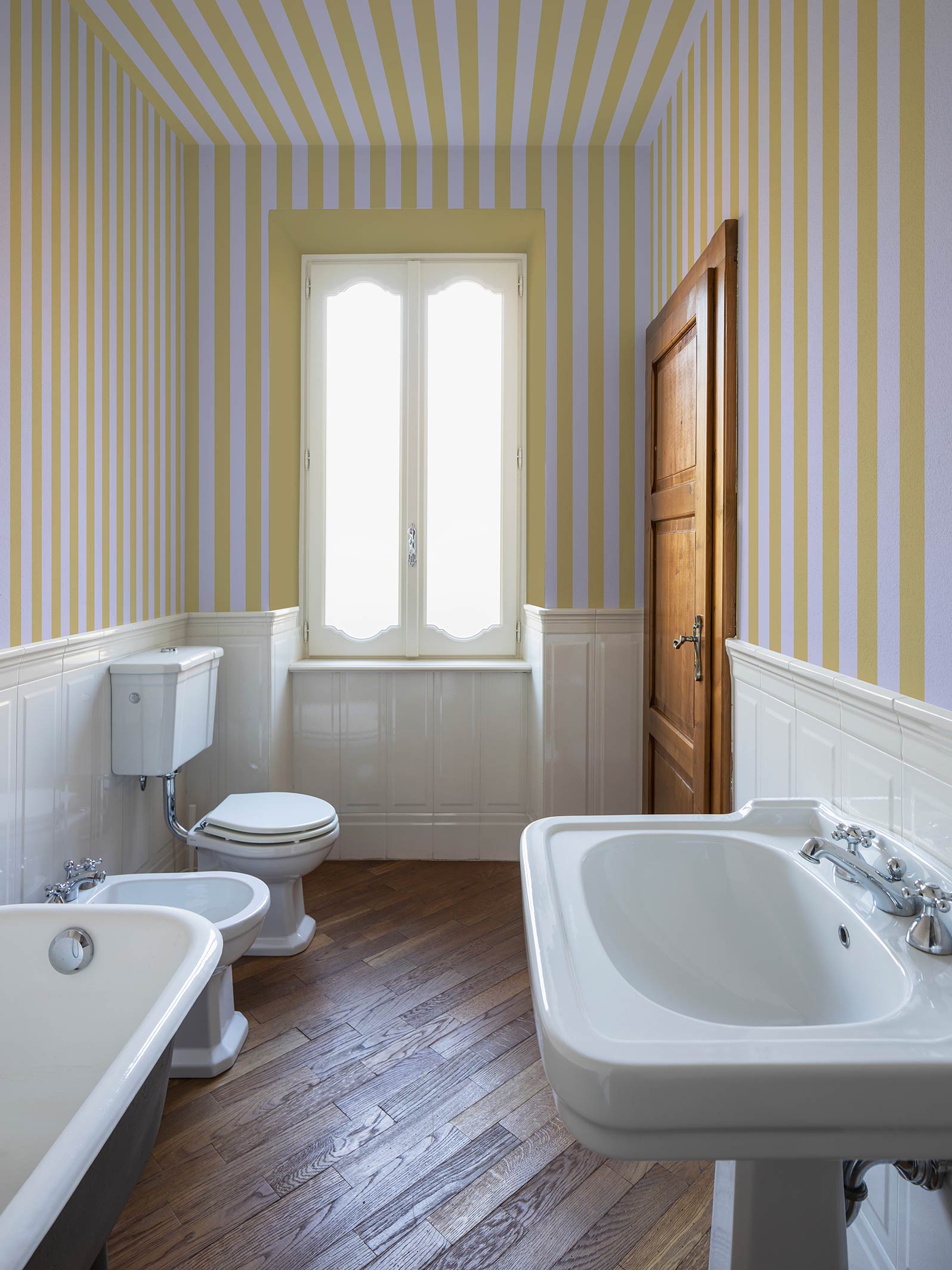 Papier peint à rayures - Eliott Gris de lin et Ocre, au mur et au plafond, dans une salle-de-bain ancienne