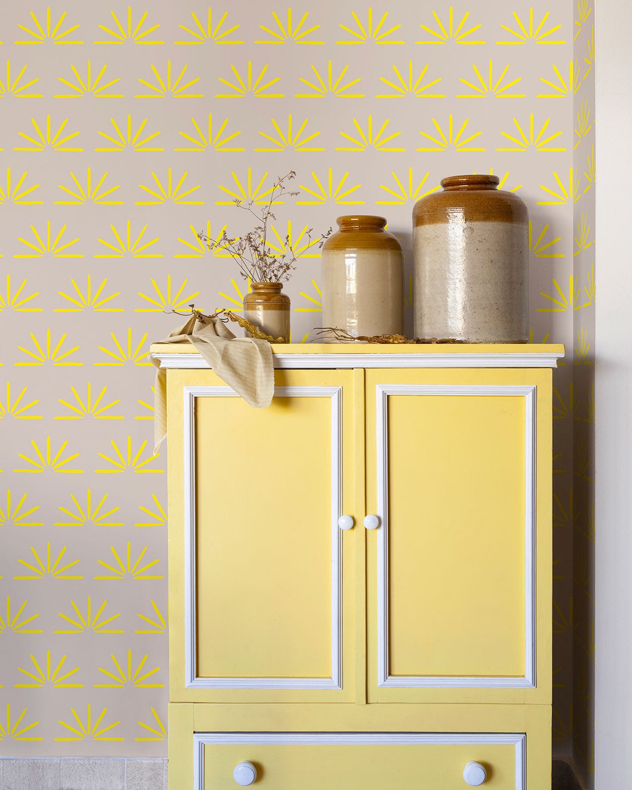 Papier peint graphique - Jeanne - Sable chaud & Jaune impérial derrière une commode jaune